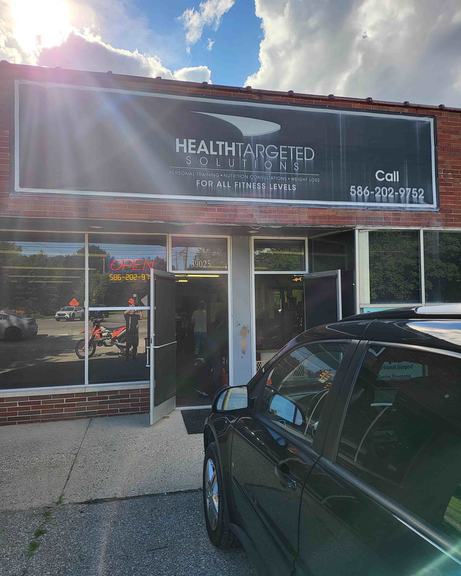 Health Targeted Solutions gym storefront with sign, logo, and phone number in Clinton Township, MI